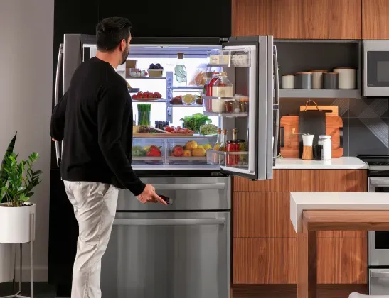 French Door capacity guide: Man shows off large, organized interior storage space with flexible drawers.